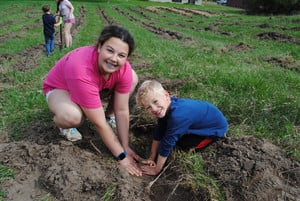 Young students planting trees with high school students